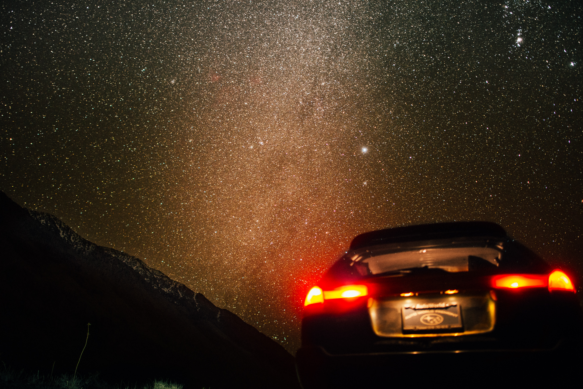 The Sky full of stars in a clear Night with a Subaru Legacy in the foreground at Death Valley, USA.